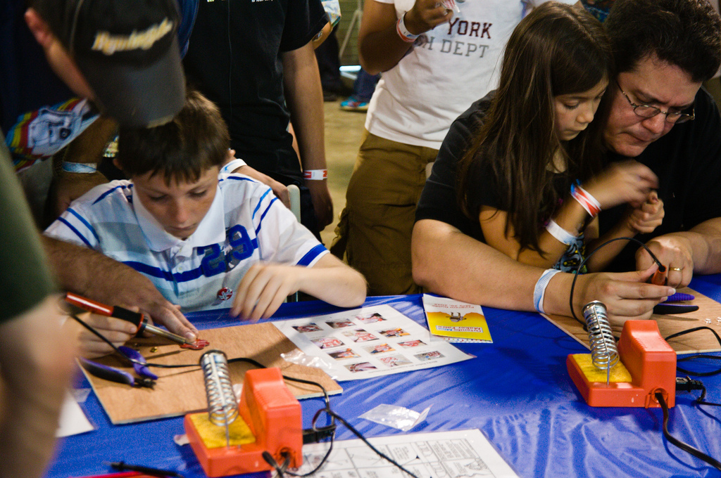 Auf dem Bild sind Personen bei der Maker Fair 2012 zu sehen