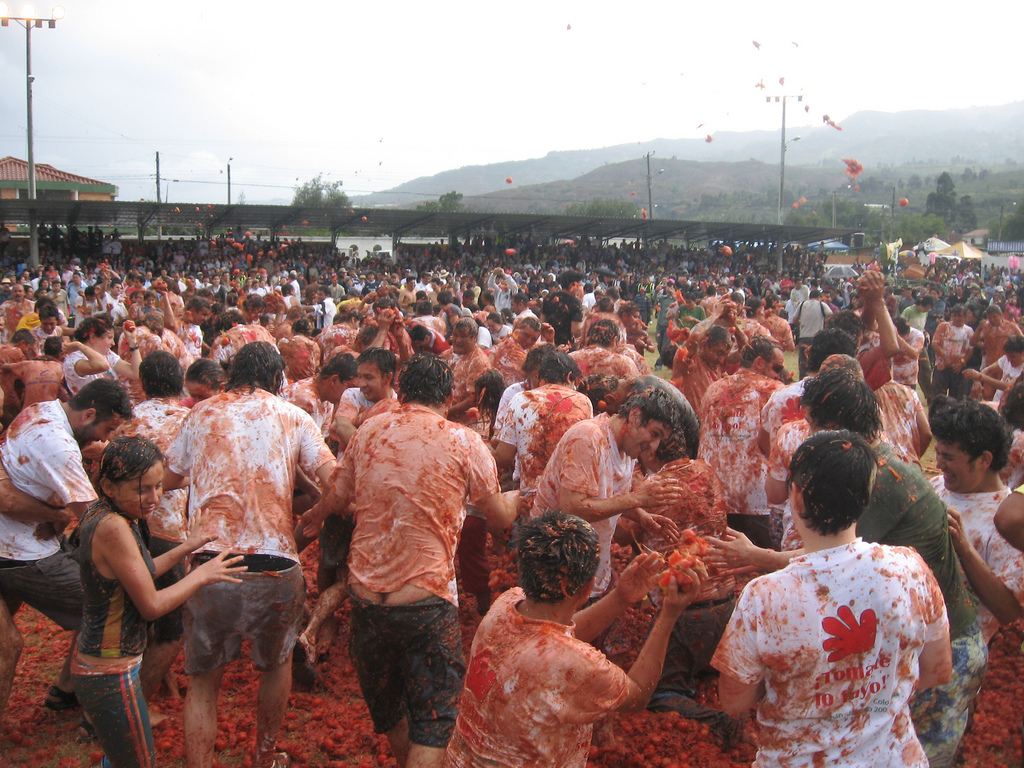 Auf dem Bild sind viele Menschen bei einer Tomaten·schlacht zu sehen