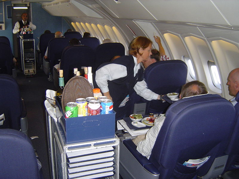 Auf dem Bild ist eine Flugbegleiterin im Flugzeug zu sehen