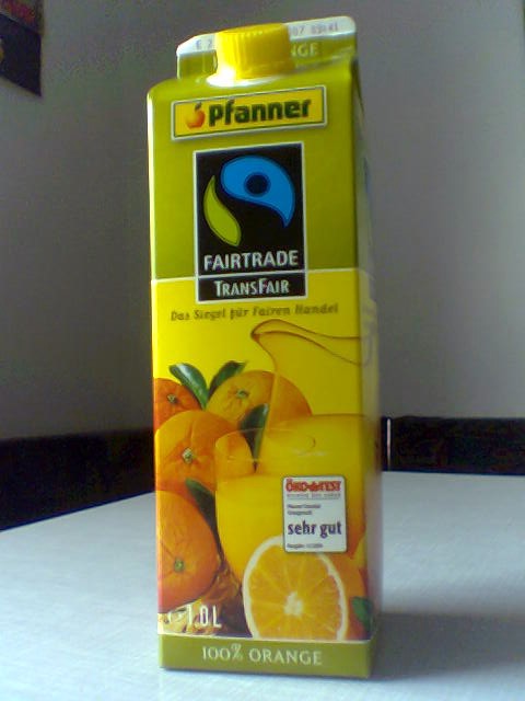 Auf dem Bild ist eine Packung Orangensaft zu sehen. Auf der Packung ist das Fair-Trade-Siegel auf-gedruckt.