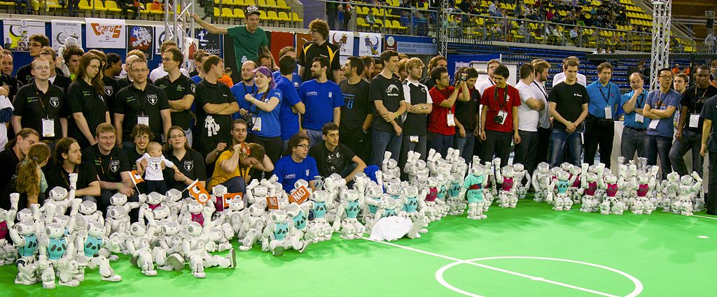 Auf dem Bild sind Roboter und Spieler beim RoboCup 2013 zu sehen