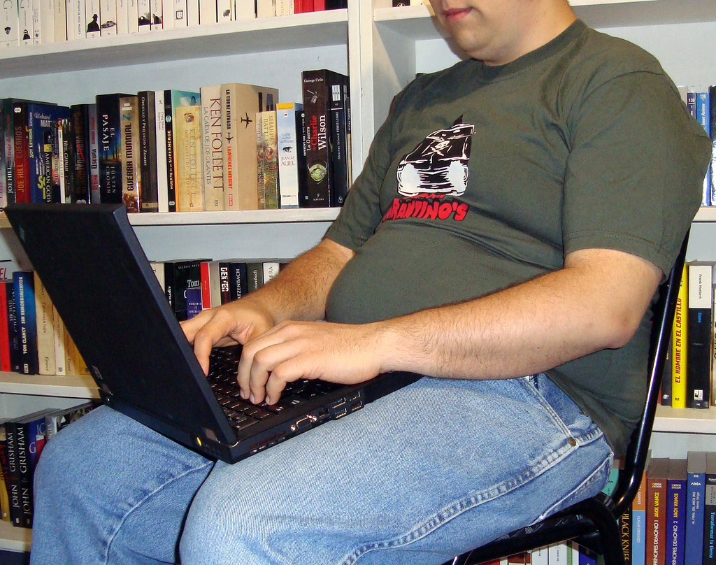 Auf dem Bild ist ein Mann mit einem Laptop zu sehen