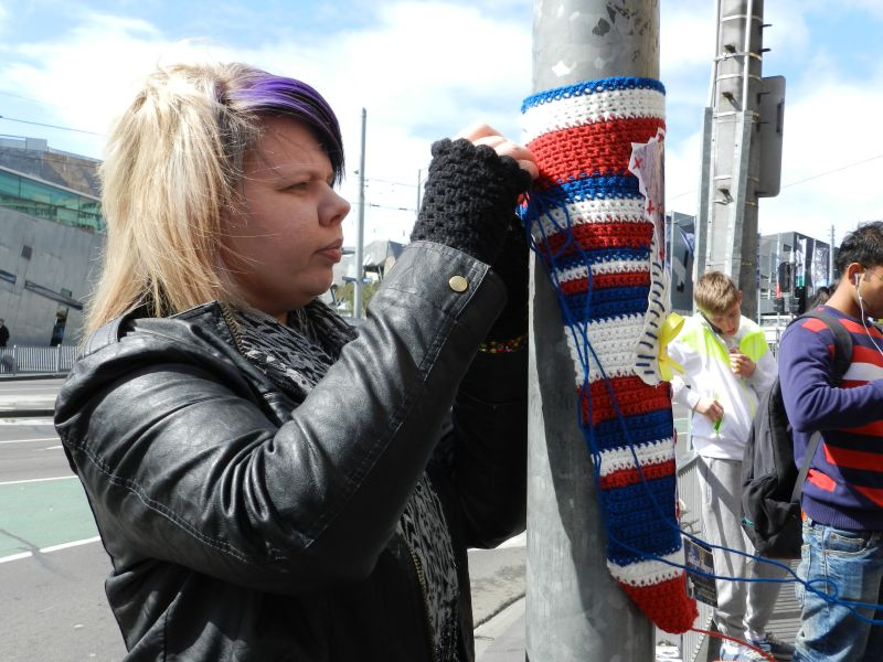 Auf dem Bild ist eine Frau beim Guerilla Knitting zu sehen