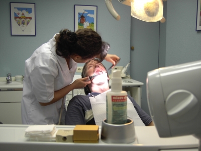 Auf dem Bild ist eine Zahnärztin und ein Patient zu sehen